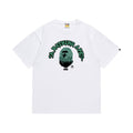 White graphic T-shirt, green outlined arched lettering and green ape graphic, front view