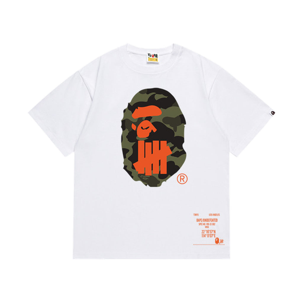 White graphic T-shirt, olive camouflage ape-head graphic with orange tally-mark design and orange lettering on front and back, front view